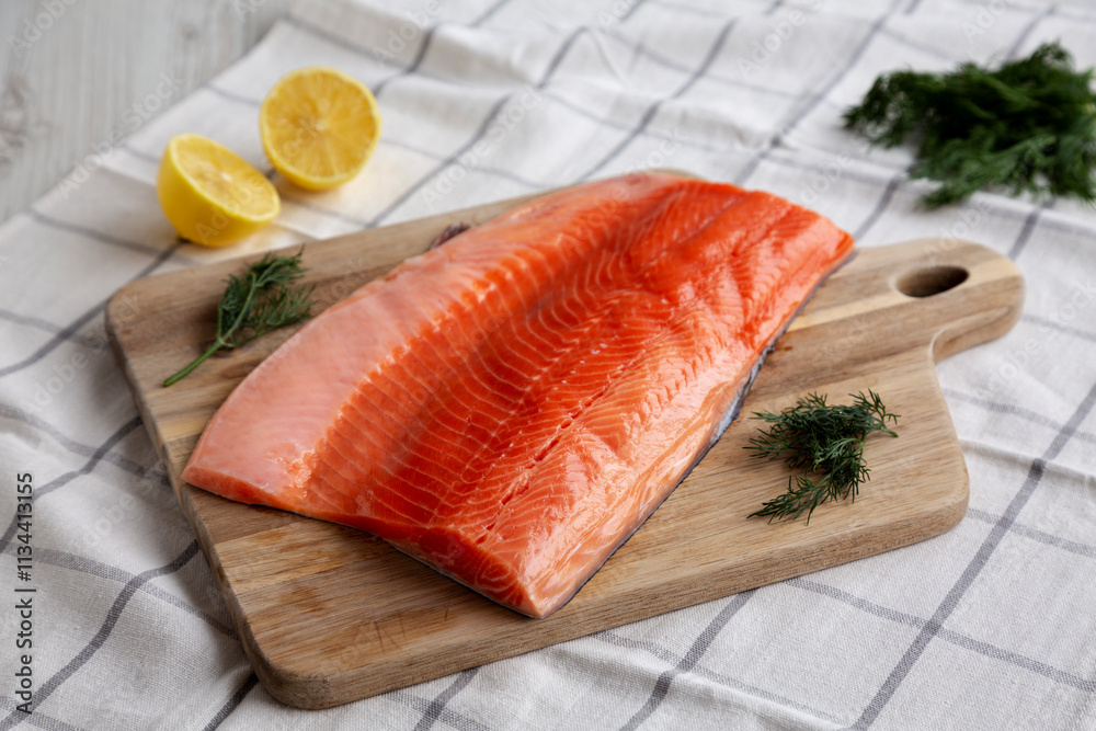 Organic Raw Salmon Fillet on a wooden board, side view. Organic Raw Salmon Fillet on a wooden board, side view.