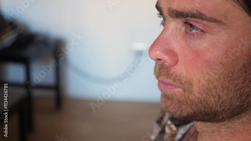 A young man opens his eyes from a nap, slowly regaining consciousness after falling asleep. photo