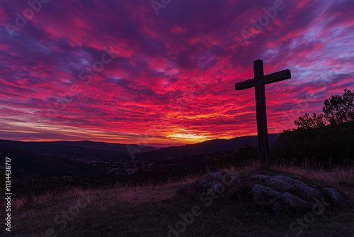 a wooden cross standing on a hill, illuminated by a radiant sunset or sunrise with vibrant hues of red, orange, and purple in the sky.