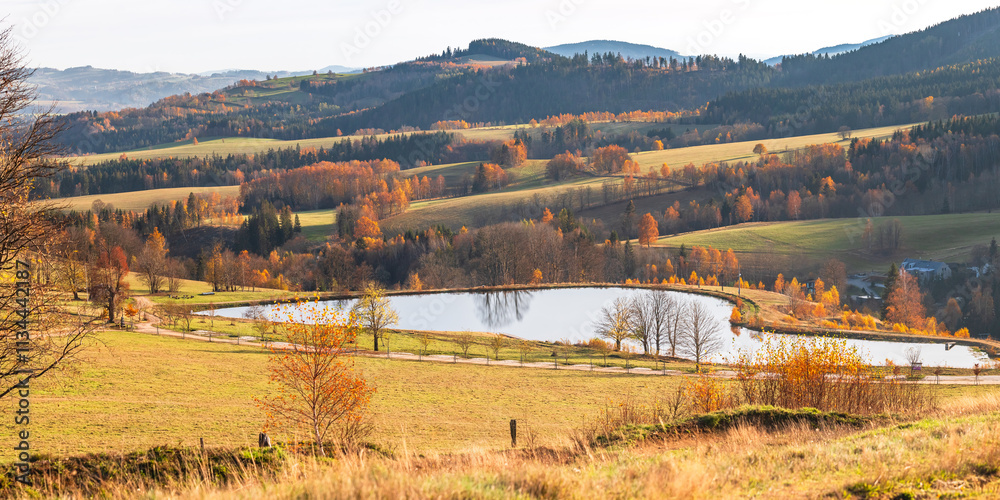 Czech Republic, Stribrnice, view from the Stvanice peak on the mountain landscape with a reservoir. Autumn landscape in the evening.