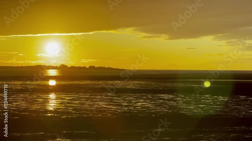 Vibrant Sunset Reflecting on the Bay of Somme’s Mudflats in October, Capturing the Golden Glow, Rippling Tidal Patterns, and a Dramatic Horizon from Le Crotoy