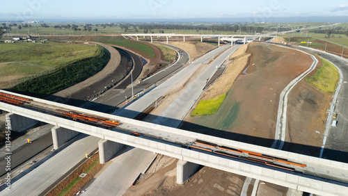 Low aerial drone view of the M12 motorway connection interchange construction site for the new Western Sydney Airport at Badgerys Creek in Western Sydney, NSW Australia in December 2024