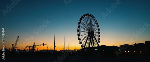 Ferris wheel silhouette against colorful sunset sky photo