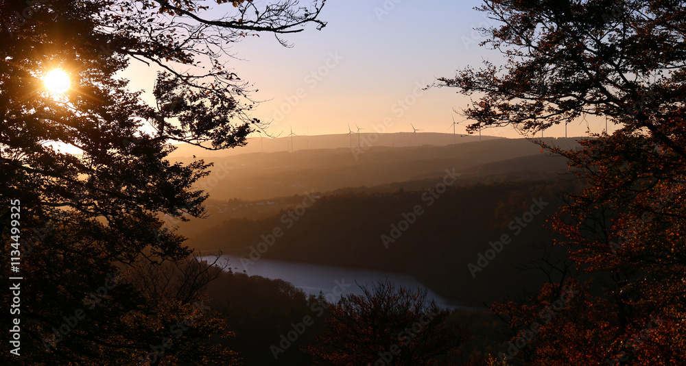 Naklejka premium Die Talsperre Nonnweiler während des Sonnenuntergangs in malerischer Natur im Herbst im Nationalpark Hunsrück-Hochwald. Aussicht von den Premium-Wanderwegen Dollbergschleife und Saar-Hunsrück-Steig.