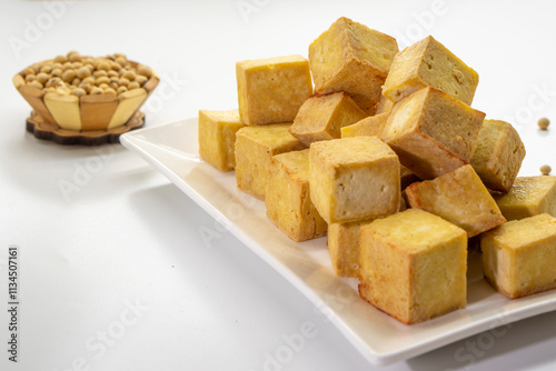 Fried tofu cubes on a plate with chopsticks. organic vegetarian tofu.  soy beans.Vegan food ingredient in Asian cuisine, Plant based diet. food concept.. Chinese food photo