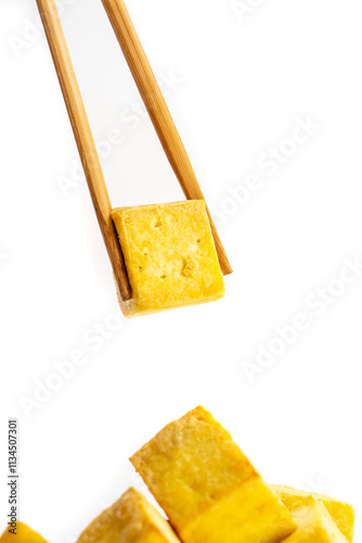 Fried tofu cubes on a plate with chopsticks. organic vegetarian tofu.  soy beans.Vegan food ingredient in Asian cuisine, Plant based diet. food concept.. Chinese food photo