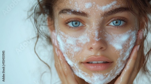 A young woman applying facial scrub, showcasing skincare routine and beauty care.