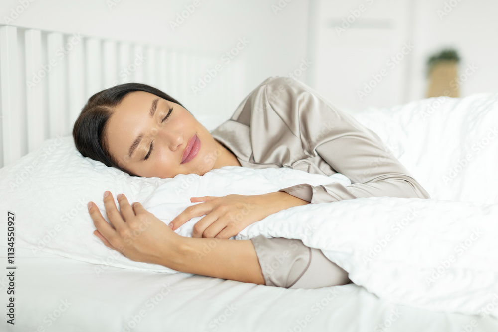Peaceful young woman sleeping, lying in bed at home and hugging pillow and blanket, having pleasant dreams. Healthy sleep concept Peaceful young woman sleeping, lying in bed at home and hugging pillow and blanket, having pleasant dreams. Healthy sleep concept