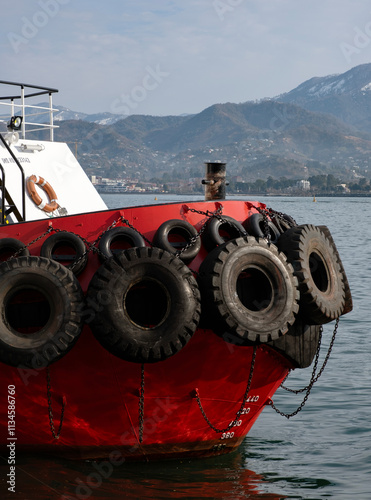 A close-up view of a modern tugboat docked in calm waters.  