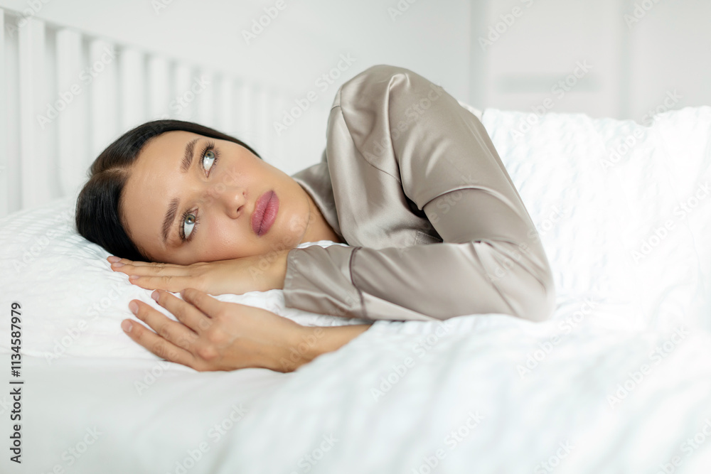 Unhappy lady lying alone awake in bedroom, feeling sad and depressed, struggling with sleep issues or loneliness. Mental health problems Unhappy lady lying alone awake in bedroom, feeling sad and depressed, struggling with sleep issues or loneliness. Mental health problems