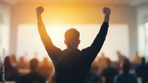 A man is standing in front of a crowd of people, raising his hands in the air
