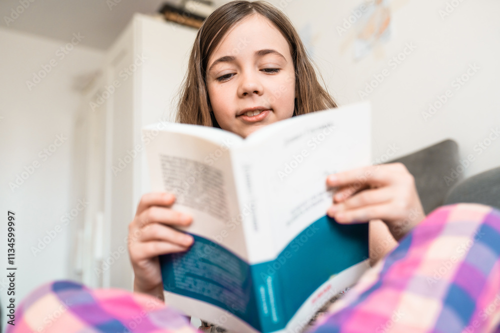 Child reads a book in a bedroom. Little girl reads a bedtime story in her room. Education concept. Child reads a book in a bedroom. Little girl reads a bedtime story in her room. Education concept.