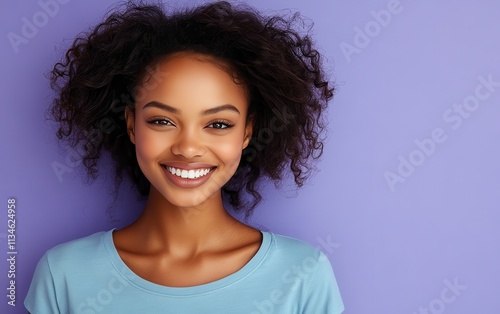 Africa American woman with curly hair is smiling in studio background