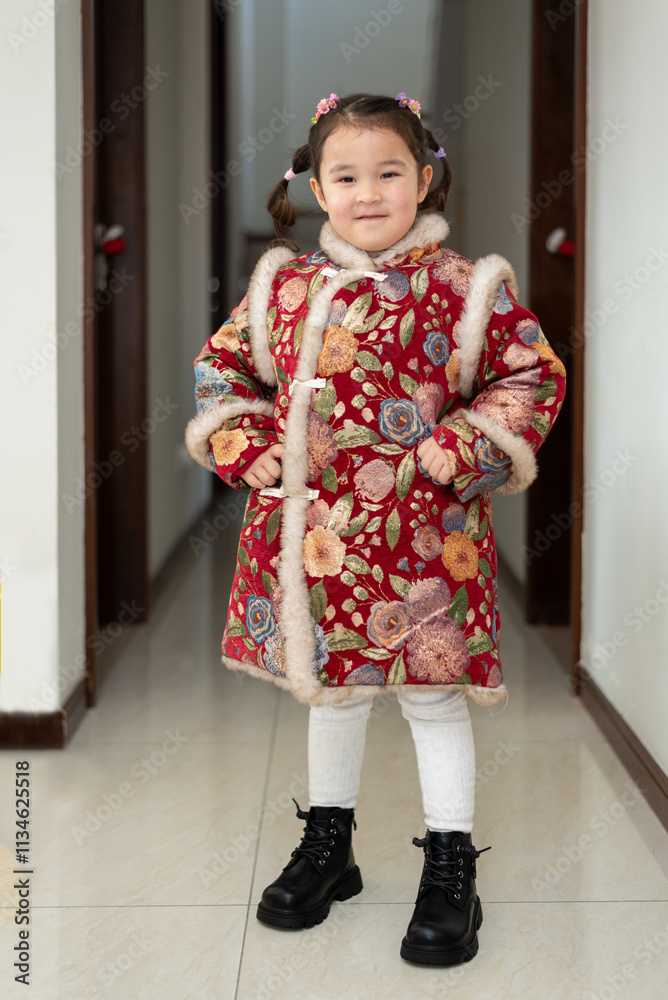 Small Chinese, multiracial girl is ready for a celebration of Chinese New Year. She is posing for a photo in her traditional Chinese dress Small Chinese, multiracial girl is ready for a celebration of Chinese New Year. She is posing for a photo in her traditional Chinese dress