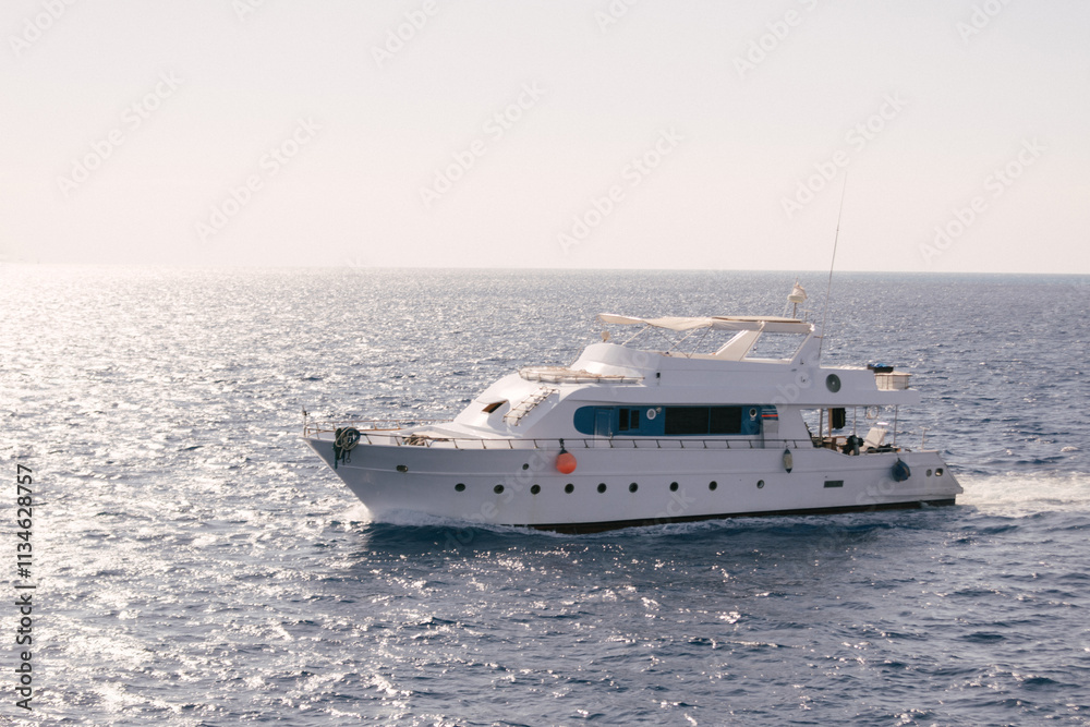 A luxury private motor yacht under way on tropical sea with bow wave A luxury private motor yacht under way on tropical sea with bow wave