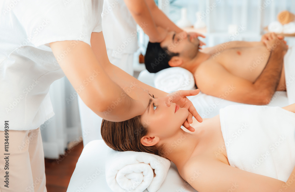 Obraz premium Caucasian couple enjoying relaxing anti-stress head massage and pampering facial beauty skin recreation leisure in dayspa modern light ambient at luxury resort or hotel spa salon. Quiescent