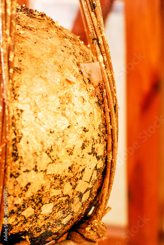 Close-up shot of round stones covered with gold leaf, the stones buried to the ground in buddhist Thai temple. Thai called LUUK NIMIT photo