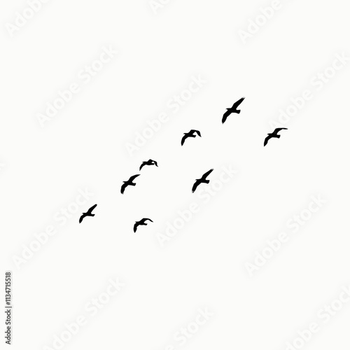 Silhouettes of a flock of birds flying against a white sky