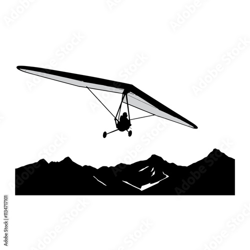 Silhouette of hang glider flying over mountains.