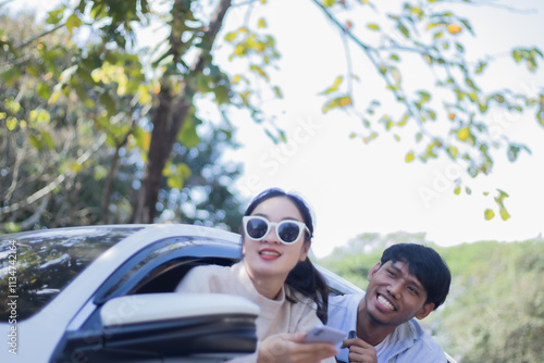 Asian male and female tourists sitting in car and looking out at pubic hair photo