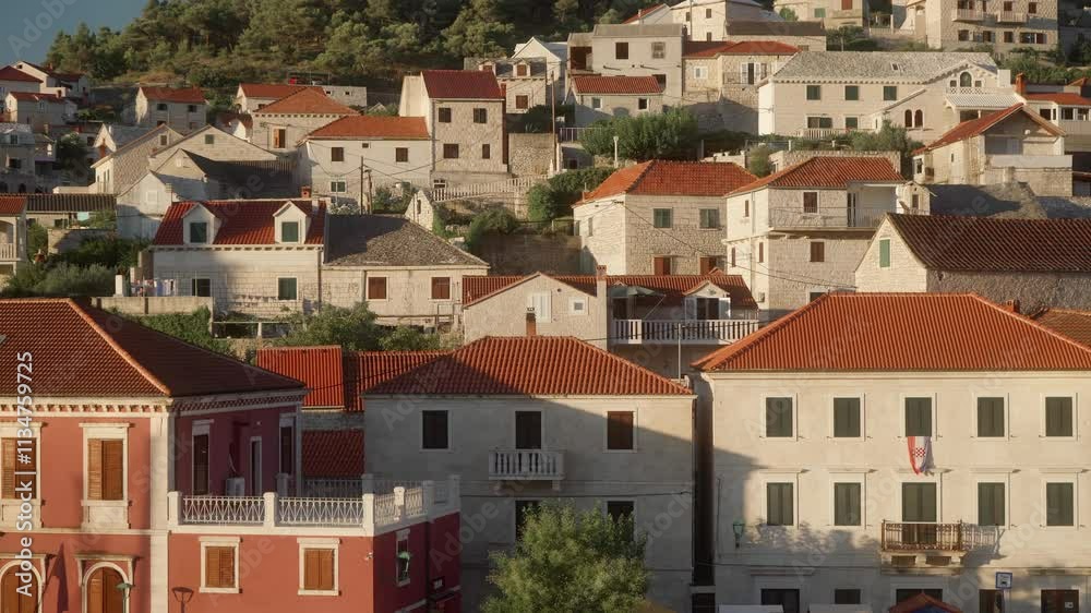 Old stone houses with tiled roofs, located on the hillside. Residential buildings and streets of the tourist town of Pucisca (Pučišća) on the island of Brac (Brač), Croatia. Mediterranean Architecture Old stone houses with tiled roofs, located on the hillside. Residential buildings and streets of the tourist town of Pucisca (Pučišća) on the island of Brac (Brač), Croatia. Mediterranean Architecture
