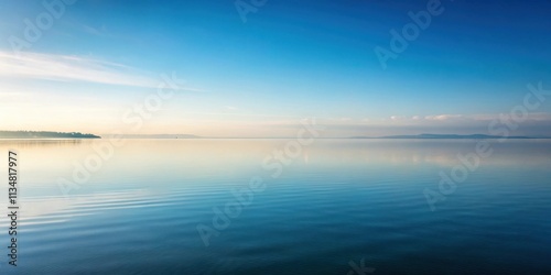 Wallpaper Mural A serene landscape of a calm lake under a clear blue sky with faint white clouds and a distant shoreline Torontodigital.ca