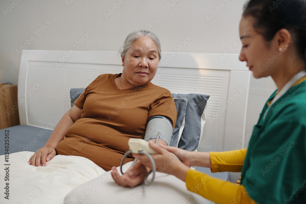 Young caregiver caring about old woman in bed at home Young caregiver caring about old woman in bed at home