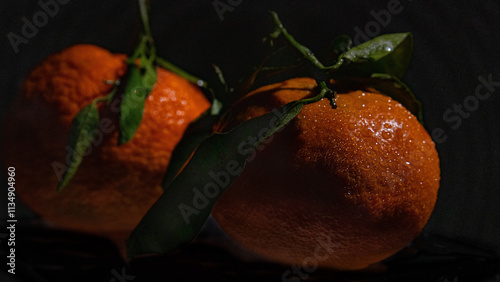 Clemetine with leaves against black background