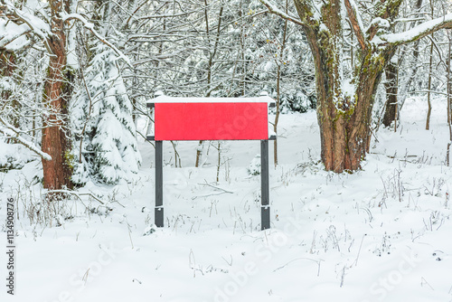 Obraz na płótnie Eastern Sudetes, red information board on a snow-covered mountain hiking trail between trees, winter landscape during the hike. w salonie