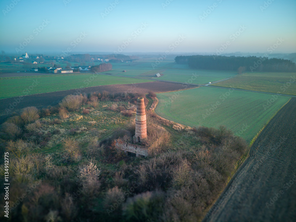 A lonely old chimney in the middle of a field.