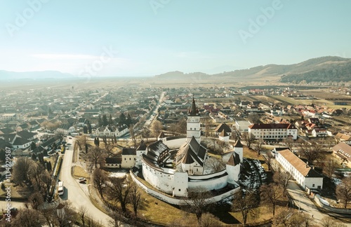 Breathtaking vista showcases the Piatra Craiului mountains as they rise majestically above the charming town of Rasnov and the serene Plaiul Foii area photo