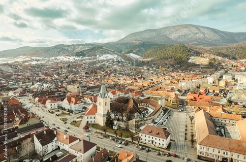 Discover breathtaking vistas of Piatra Craiului mountains and the picturesque towns of Rasnov and Plaiul Foii in Brasov, Romania, under a captivating sky with clouds photo