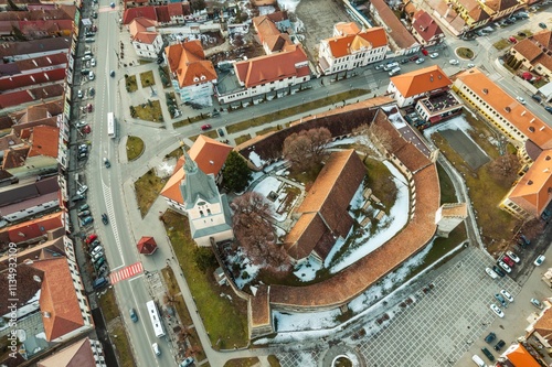 Enchanting aerial view captures the breathtaking landscapes of Piatra Craiului, highlighting the charm of Rasnov and Plaiul Foii. Winter coats the historic area in a serene blanket of snow photo