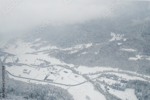 Snow blankets the picturesque valleys and hills of Piatra Craiului, creating a serene winter wonderland. The tranquil landscape showcases the beauty of Rasnov and Plaiul Foii photo