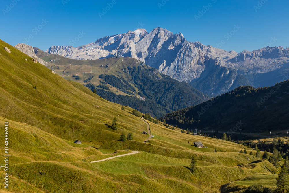Obraz premium Marmolada peak, the highest mountain in the Dolomites. The rocky wall of Marmolada summit in Dolomiti Alps. The green valley and glacier of Marmolada top