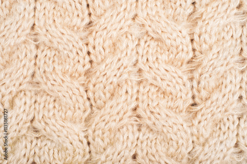 Cozy background of beige knitted texture with cables and braids