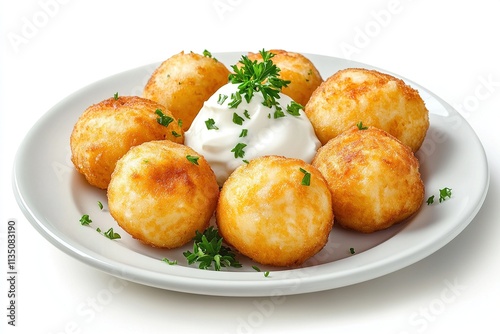 Belarusian kolduny dumplings served on a clean white plate with sour cream and parsley garnish. photo