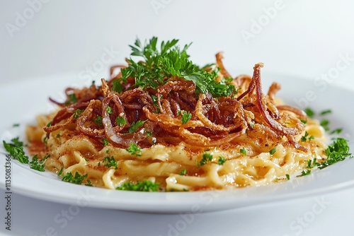 A plate of kÃ¤sespÃ¤tzle (cheese noodles) garnished with crispy fried onions and fresh parsley. photo