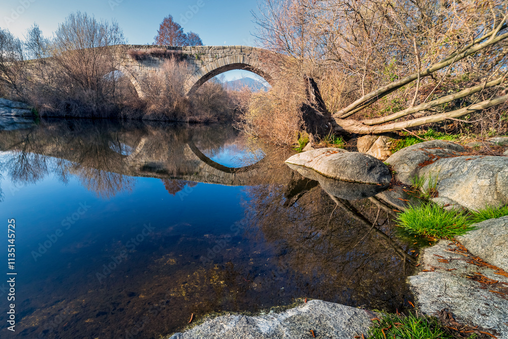 Fototapeta premium Historical roman bridge of Valsordo over river Alberche