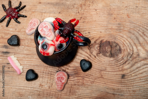 marmalade in the shape of an apple, heart and skull in a black mug on a wooden background. Halloween flatley photo