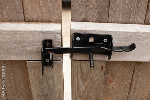 Wood gate with black metal latch, lock