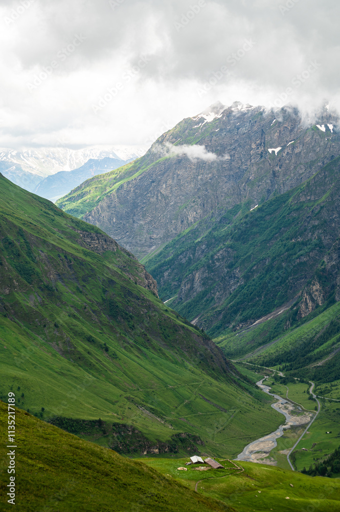 Fototapeta premium LES CHAPIEUX, FRANCE : Mountains chain with lonely farm at the hill side. The region is a stage at the Mont Blanc tour, which crosses three countries. 