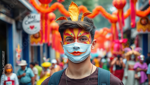 A man wears a colorful feathered mask at Mardi Gras in New Orleans, surrounded by festive lanterns and the lively atmosphere of pre-Lenten celebrations.