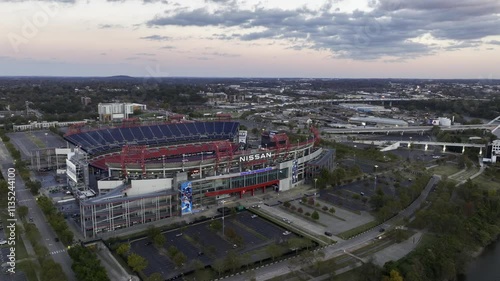 Aerial drone footage of downtown Nashville skyscrapers during a beautiful pink and purple sky sunset. Video taken in late October with colorful trees lining the Cumberland River.