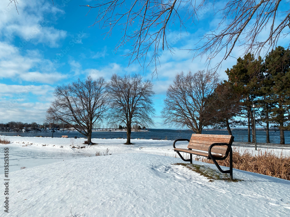 Snowy Park Bench by Frozen Lake on Winter Day Snowy Park Bench by Frozen Lake on Winter Day