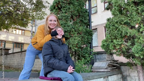 Surprise unfolds as a woman covers a girl's eyes in the city, revealing a joyful moment filled with excitement and love