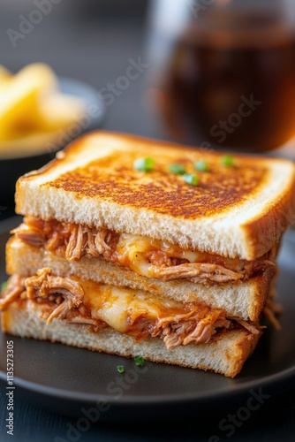 Pulled pork sandwich served with fries and cold drink on a wooden table