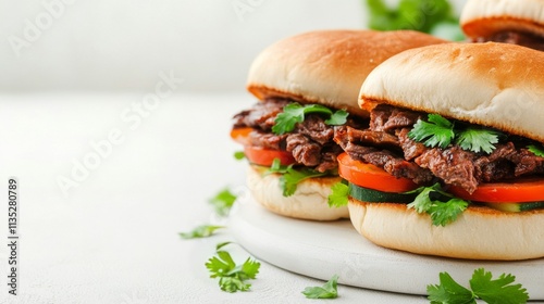 Delicious steak sandwiches with fresh vegetables and herbs served on a white ...