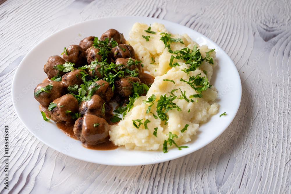 Swedish Meatballs with Gravy Sauce on a plate with mashed potatoes on a wooden background