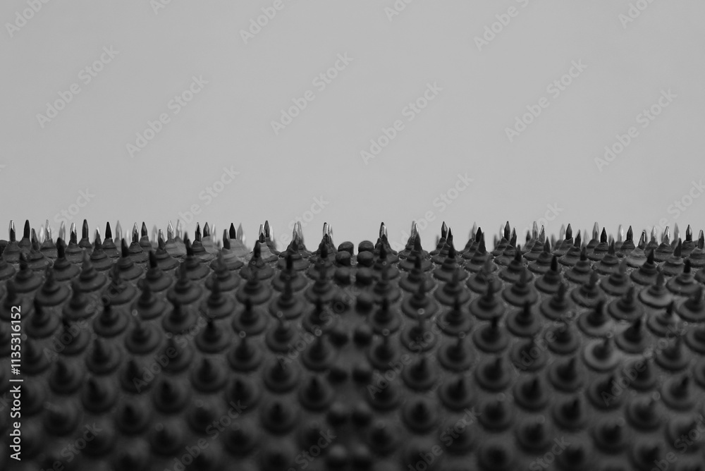 Obraz premium Macro photo of a studded surface with multiple sharpened metal points with copy space over it 